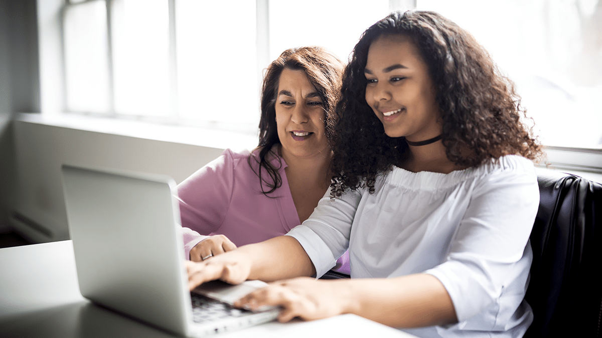 Mother and daughter looking at computer together