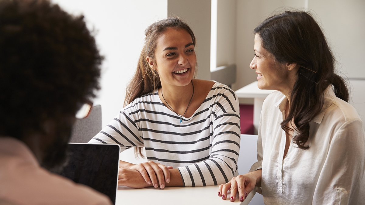 Mother And Daughter Meeting With Male Teacher