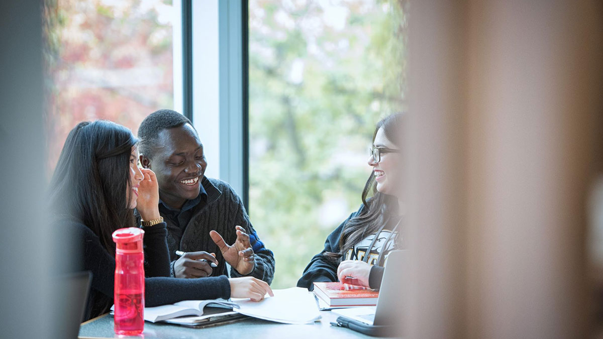 Three UBC students studying around a table together