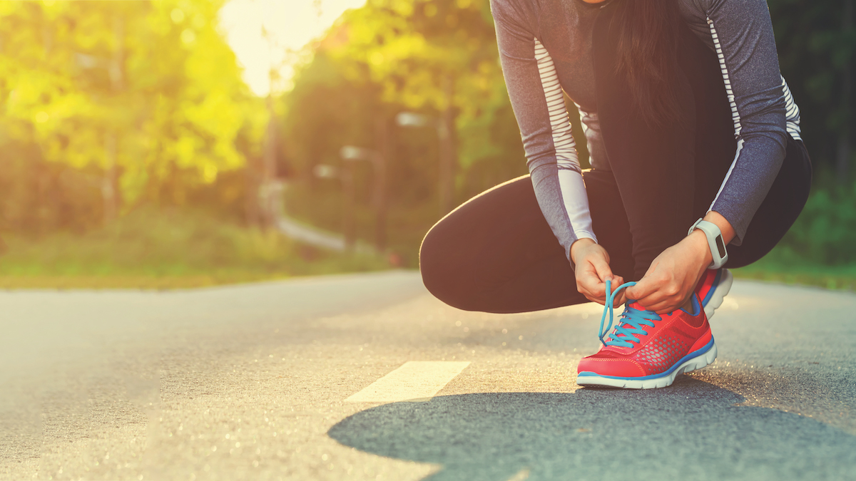 Female runner tying her shoes preparing for a jog